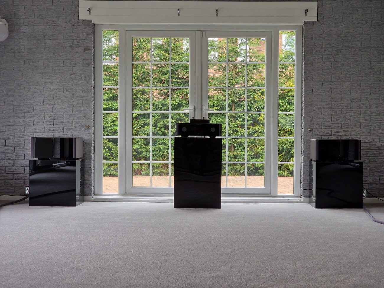 A high-end listening room with reference floorstanders and subwoofers